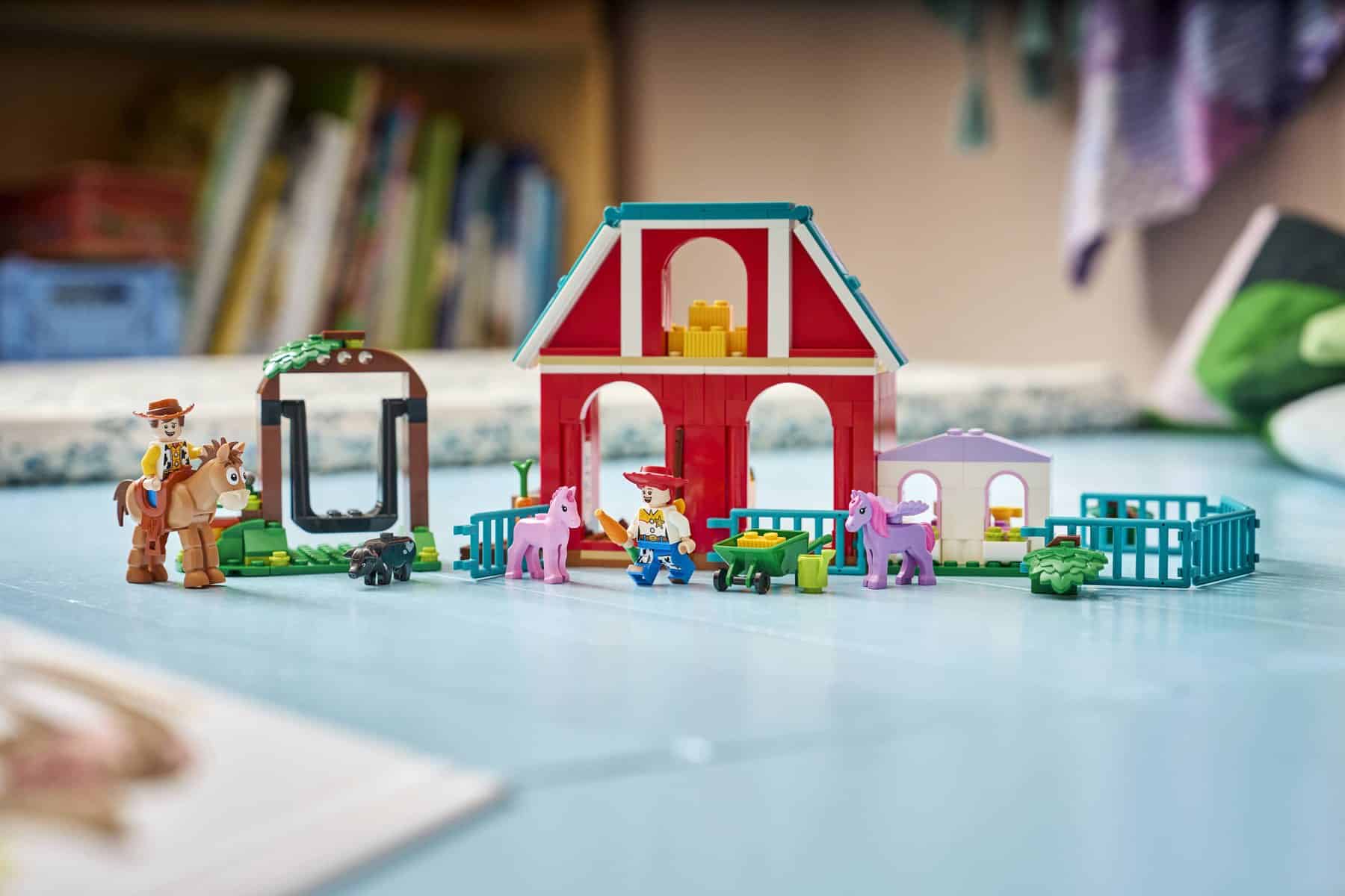 A LEGO® ǀ Disney and Pixar Toy Story 5 Blaze’s Horse Ranch featuring minifigures and accessories displayed on the floor.