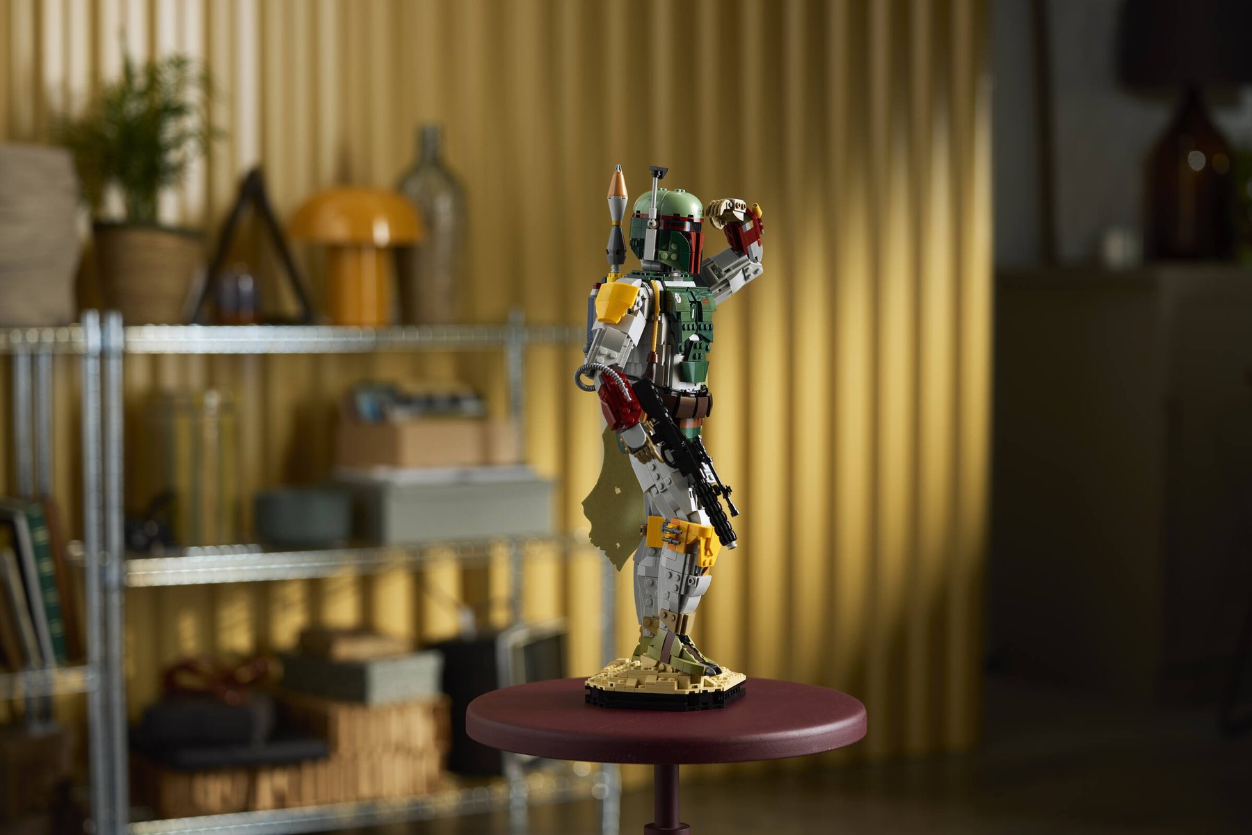 Built LEGO® Star Wars™ Boba Fett displayed on a small round table; soft decor behind.