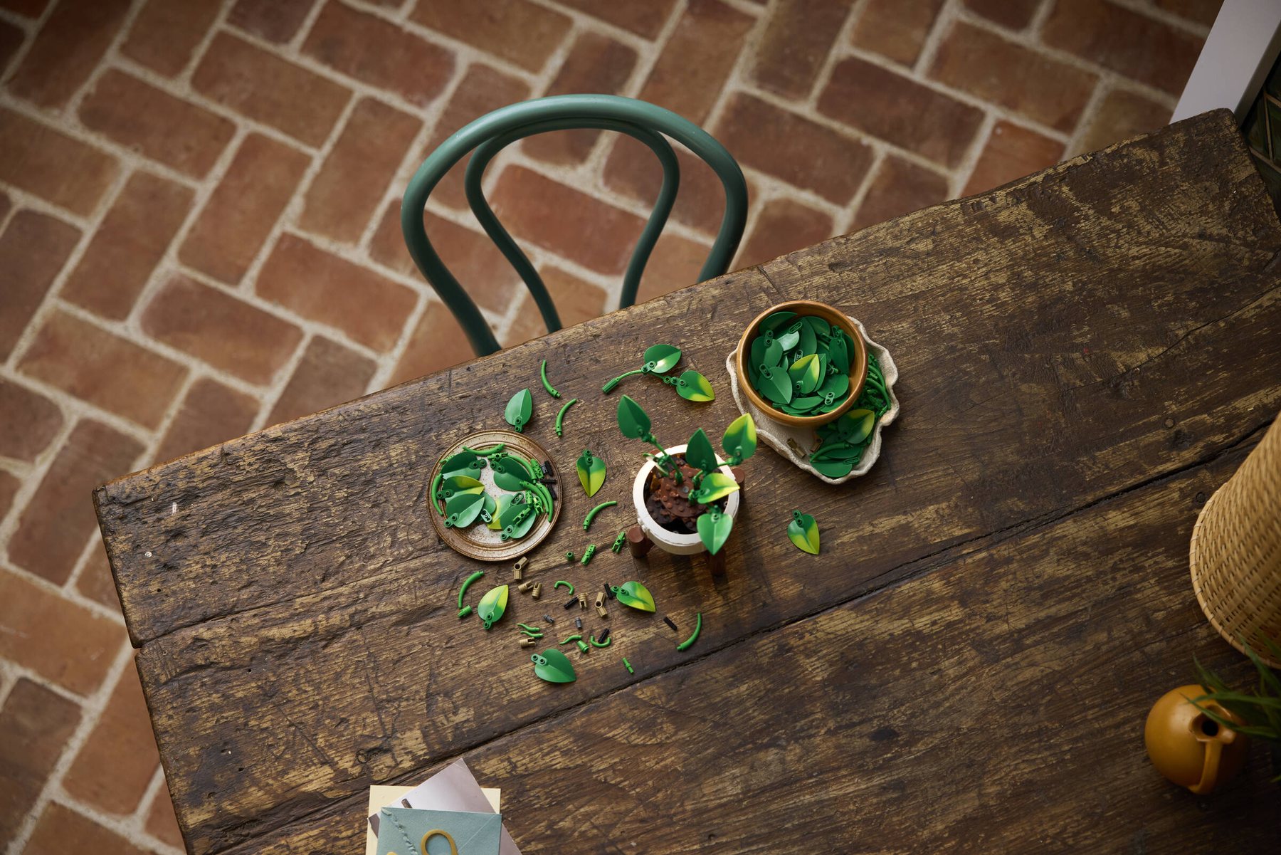 Aerial view of a partially built LEGO® Botanicals Hanging Golden Pothos set with pieces scattered across a table.