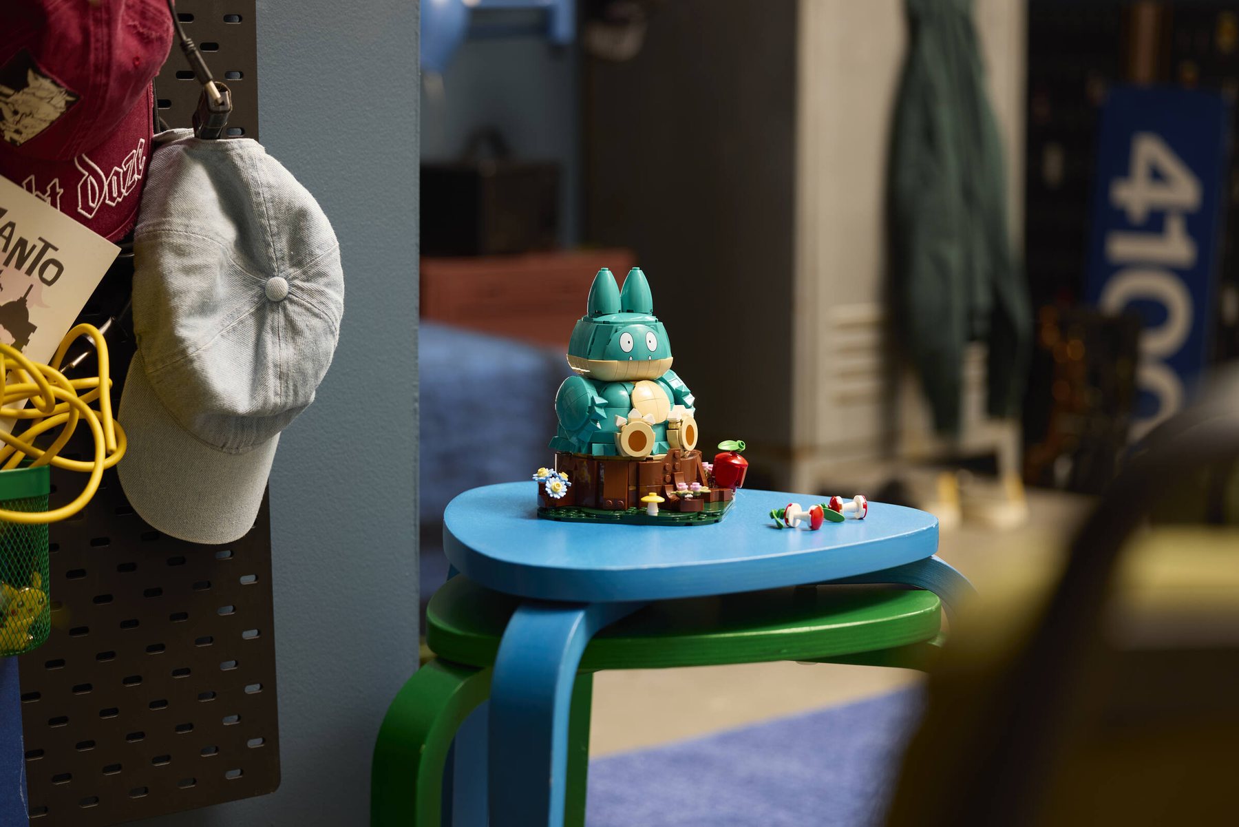 LEGO® Pokémon™ Munchlax shown beside its detached baseplate and accessories, holding an apple core.