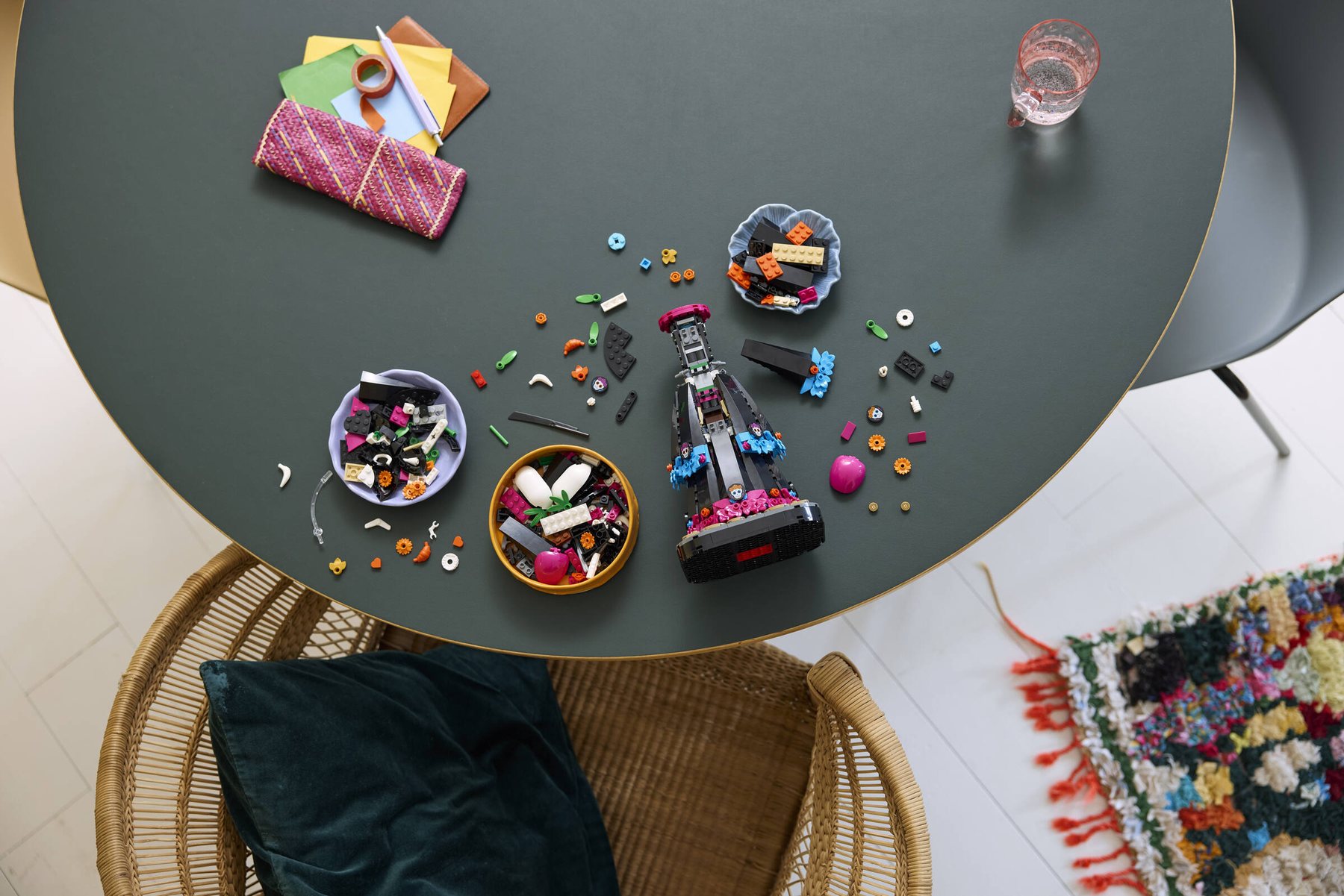 Partially built LEGO® Ideas La Catrina set on a table with bowls containing LEGO bricks nearby.