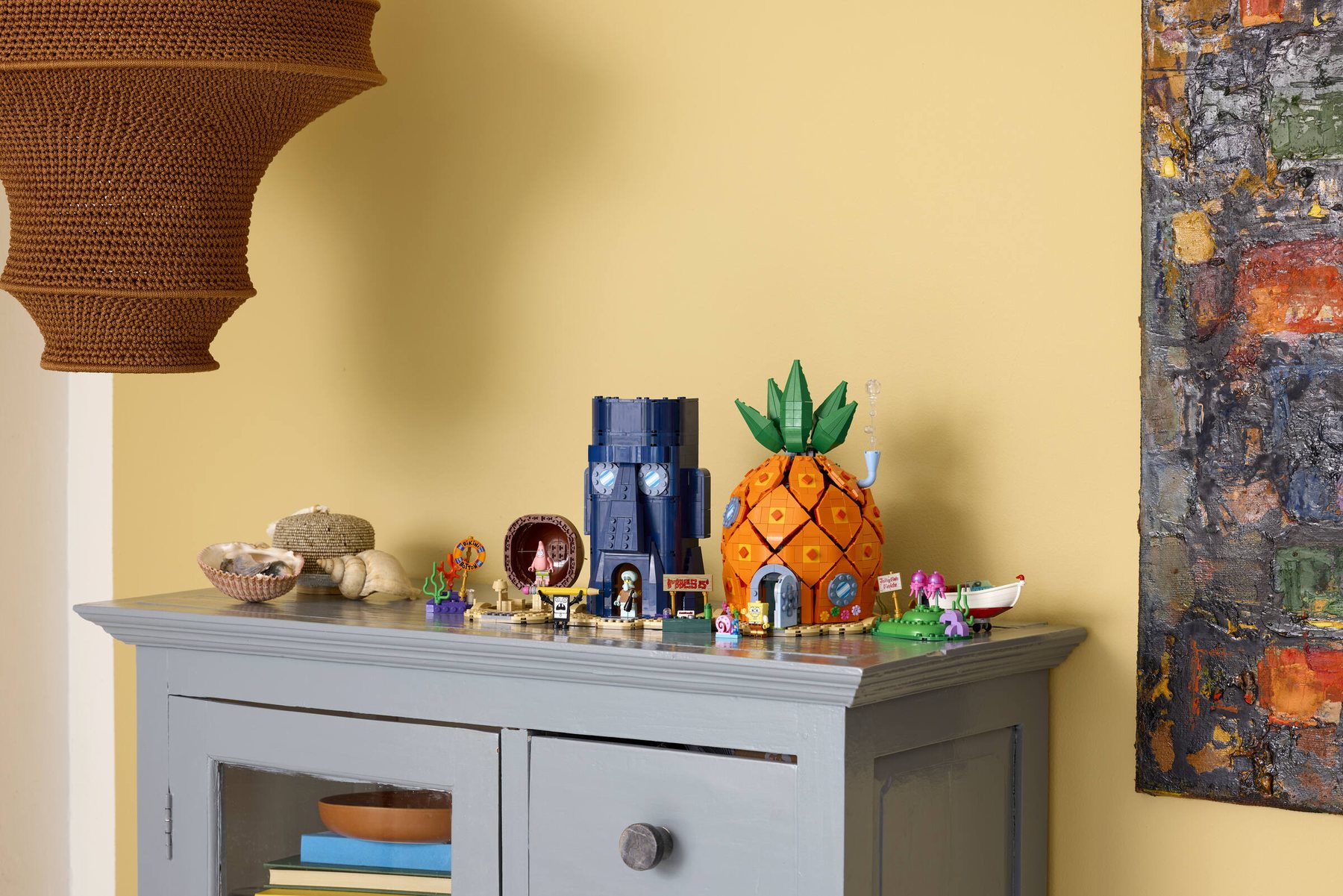 A LEGO® Icons SpongeBob SquarePants: Bikini Bottom set featuring a pineapple house and minifigures shown on a sideboard.
