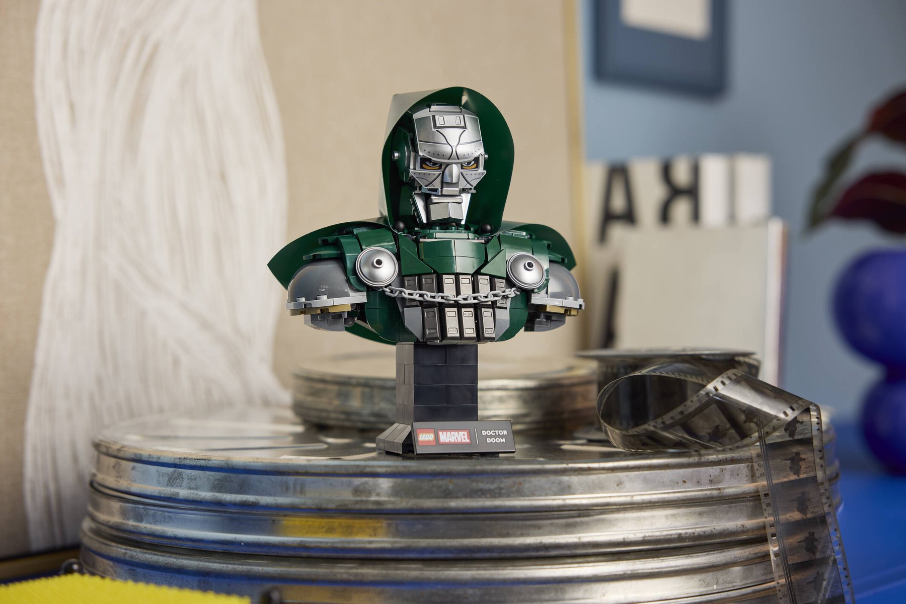 LEGO® ǀ Marvel Doctor Doom Bust on a stand with a nameplate, displayed on a metal movie film canister.
