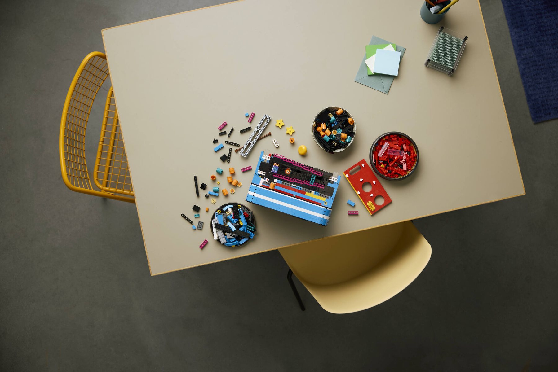 Aerial view of a partially built LEGO® Donkey Kong™ Arcade on a table, surrounded by loose pieces.