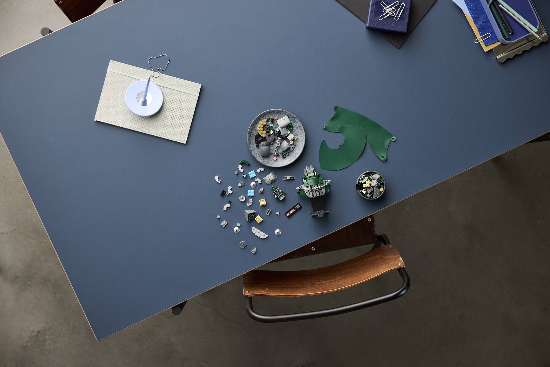 Aerial view of a partially built LEGO® ǀ Marvel Doctor Doom Bust on a table, surrounded by loose pieces.