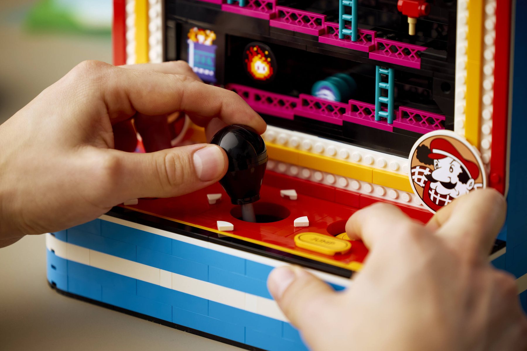 Close-up of hands moving the joystick on a LEGO® Donkey Kong™ Arcade set.