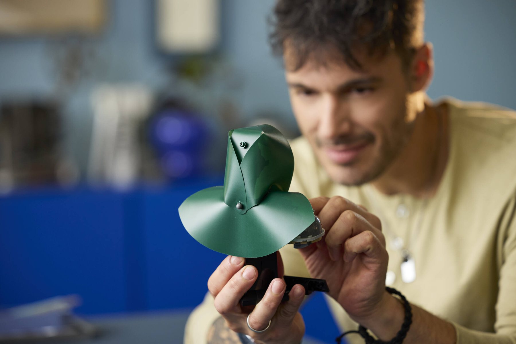 Close-up of a man holding and building a LEGO® ǀ Marvel Doctor Doom Bust, with the set seen from the back.