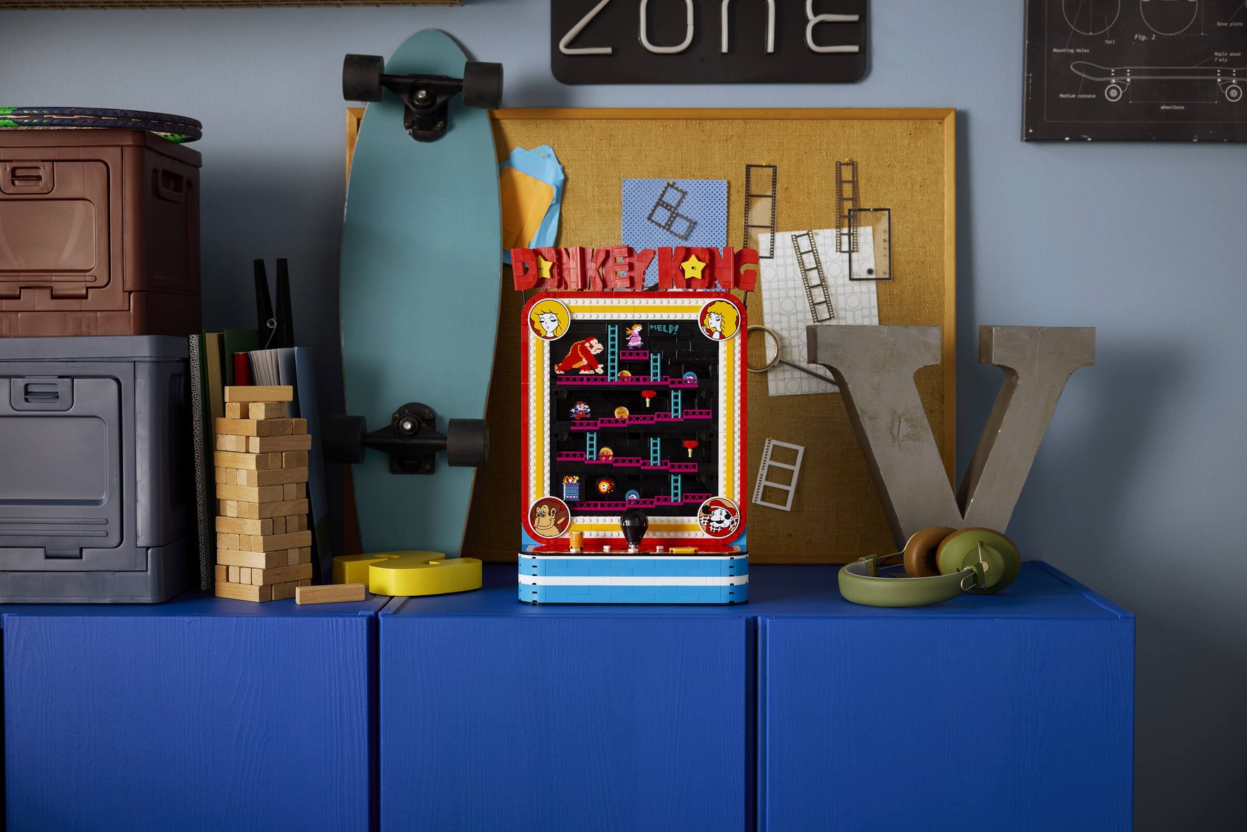 LEGO® Donkey Kong™ Arcade set displayed on a sideboard, next to a skateboard and a pair of headphones.